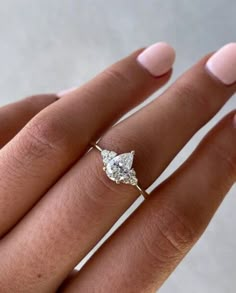 a woman's hand with a diamond ring on it