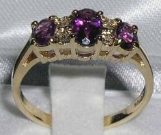 *This beautiful ring is made from 375 9K (9ct 9Kt) Yellow Gold with Genuine Natural 1.12 carats Semi-precious Amethysts & Genuine Natural 0.04 carats Precious Diamonds.*Total metal weight : 1.9gA beautiful traditional style Amethyst set with a center 6x4mm (0.24" x 0.20" inches) and two 5x4mm (0.20" x 0.16" inches) vibrant Amethysts and four Diamonds in an adorable 9K Yellow Gold setting.*Total Height 3mm, Width 16mm,  Length 6mm   Completely made from Solid English 9K Yellow Gold Hallmarked Gold Three Stone Amethyst Ring Gift, Gold Amethyst Three Stone Ring As A Gift, Gold Amethyst Three Stone Ring Gift, Gold Three-stone Amethyst Ring For Anniversary, Classic Three Stone Amethyst Ring For Anniversary, Anniversary Yellow Gold Three-stone Amethyst Ring, Engagement Ring Trilogy, Amethyst Set, Yellow Gold Setting