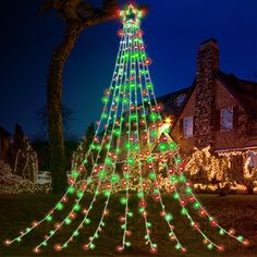 a lighted christmas tree in front of a house