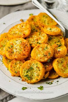 a white plate topped with fried potatoes covered in parmesan cheese and seasoning