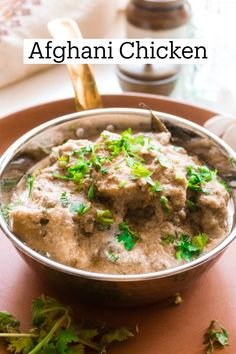 a bowl filled with food on top of a wooden table next to a fork and spoon