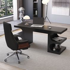 an office desk with a laptop on it in front of a bookcase and window