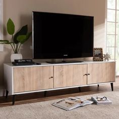 a flat screen tv sitting on top of a wooden entertainment center in a living room