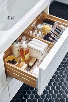 an open drawer in a bathroom filled with cosmetics