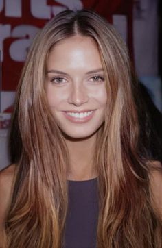 a woman with long hair smiling for the camera