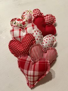 several red and white heart shaped cushions sitting on a table