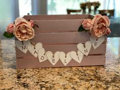 a wooden box with flowers and hearts on it