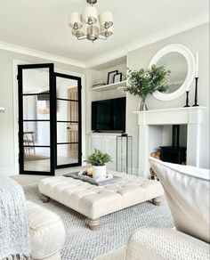 a living room filled with furniture and a fire place in front of a tv mounted on a wall