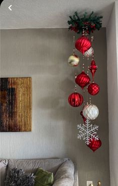 a living room with ornaments hanging from the ceiling and a couch in front of it