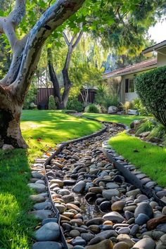 Creative Drainage Ditch Ideas for Your Yard Backyard Ditch Landscaping, Landscape Drainage Ditch, Landscape Ideas For Water Drainage, Landscaping Water Drainage, Diy Water Drainage Landscaping, Backyard Water Drainage Ideas, Diy Drainage Ditch Landscaping, Stone Drainage Ideas, Downspout Drainage Ideas River Rocks