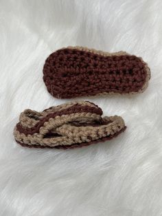 two crocheted slippers laying on top of a white furnishing area