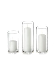 three clear glass vases with white candles in them