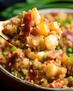 a spoon full of rice with bacon and peas