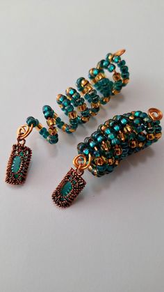 three pieces of beaded jewelry sitting on top of a white table next to each other