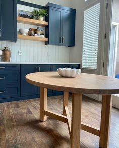 a wooden table in a kitchen with blue cabinets