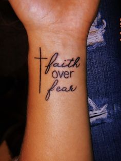 a wrist tattoo with the words faith over fear on it