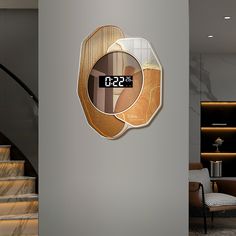 a clock that is on the side of a wall next to some stairs in a building