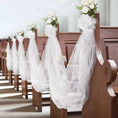 flowers are placed on the back of pews