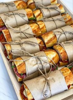 sandwiches wrapped in brown paper and tied with twine on top of each other, ready to be eaten