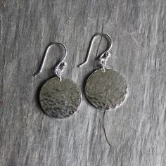 Do you need a gift for someone special? These simple sterling silver dangly hammered disc earrings are cute, simple & go with every outfit. Here are the details: This pair of earrings is made with solid sterling silver 3/4" diameter discs, have a hammered finish and are completed with handmade sterling silver ear wires. Sterling Silver Round Disc Jewelry With Matching Earrings, Sterling Silver Jewelry With Matching Earrings, Round Disc Shape, Sterling Silver Jewelry With Matching Earrings And Round Disc, Hammered Sterling Silver Round Disc Earrings, Dainty Sterling Silver Hammered Earrings, Dainty Hammered Sterling Silver Earrings, Simple Hammered Sterling Silver Jewelry, Hammered Silver Round Disc Earrings, Simple Hammered Silver Jewelry