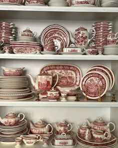 red and white china is displayed on shelves