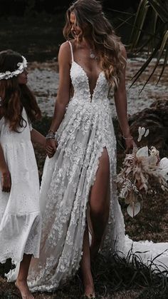 two women in white dresses holding hands