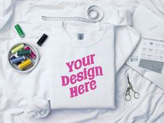 a t - shirt that says your design here next to scissors, markers and pens