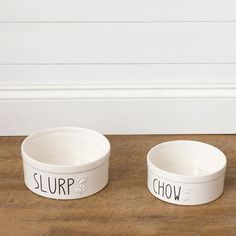 two white bowls with words that say slurp, chow and chow on them