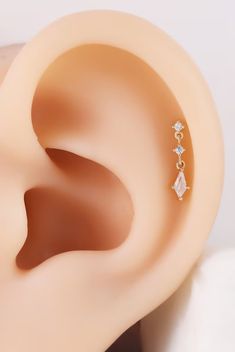 an ear is shown with three diamonds on it