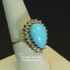 Pretty Levian Sleeping Beauty Turquoise diamond ring, This cabochon is cut in a cute teardrop shape and has a halo of round brilliant diamonds. Ring Size: 7 Total Weight: 8.31 grams Precious Metal: 14k yellow gold Precious stones: -Sleeping Beauty Turquoise Center Stone: 17mmx11.5mm, 13.8 carats -White Round Diamonds: 0.63 carats Hallmark: Levian, 14k Formal Turquoise Diamond Ring With Gemstone, Formal Turquoise Diamond Ring, Formal Fine Jewelry Turquoise Diamond Ring, Fine Jewelry Turquoise Ring With Diamond Accents, Elegant Turquoise Ring With Diamond Accents, Elegant Turquoise Cabochon Diamond Ring, Elegant Turquoise Ring With Diamond Accents As Gift, Oval Diamond Turquoise Ring For Formal Occasions, Formal Oval Turquoise Ring With Diamond