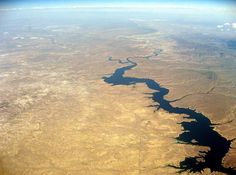 an aerial view of the water and land in the middle of the desert, taken from above