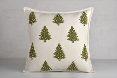 a green and white christmas tree pillow on a grey background with polka dotty dots