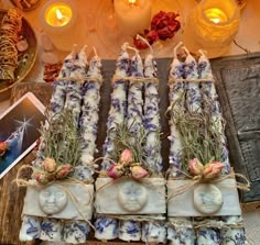 several candles are wrapped in twine and decorated with lavenders, roses and herbs