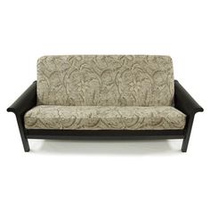 a couch that is sitting in front of a white wall with a black wooden frame