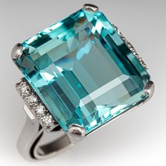 This striking ring is centered with one (1) emerald cut natural aquamarine set into a four-prong setting. The shoulders of the ring are each accented with a row of four (4), bead set, round single cut diamonds. The ring measures 18.6mm at the top, rises 11.5mm above the finger, tapering to 2.5mm wide and 1.8mm thick at the base of the shank. This ring is currently a size 7.75. Aquamarine Cocktail Ring, Old Boxes, Bead Set, Greenish Blue, Natural Aquamarine, One 1, Cocktail Ring, High Quality Jewelry, Cocktail Rings