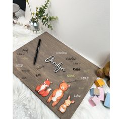 a wooden board with the names of different animals on it and a teddy bear next to it