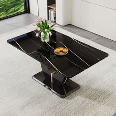 a black marble dining table with gold trimmings and flowers in a vase on top