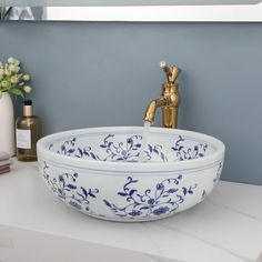 a blue and white bowl sink sitting on top of a counter next to a faucet