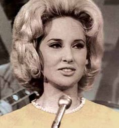 an old photo of a woman with blonde hair holding a microphone in front of her face