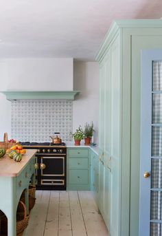 a kitchen with blue cabinets and wooden floors