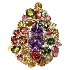 Bochic "Orient” Amethyst & Multi Tourmaline Cocktail Ring 18K Gold & Silver Natural Pear Shape Amethyst - 7 Carat Natural Multi Color Tourmaline - 17.50 Carat This Ring is from the "Orient" traveling collection are the epitome of elegance and versatility. It offers a perfect blend of day to night and swimwear to evening wear, allowing you to effortlessly transition between different occasions and outfits. Wearing these spectacular oriental-style ring will undoubtedly make you the center of attention. It addw a touch of glamour and sophistication to your favorite caftans, swimwear, or evening attire, enhancing your overall look. The "Orient" collection, from which this ring originates, showcases exceptional craftsmanship and incorporates natural gemstones. The ring is set in 18k gold and si Artistic Luxury Gemstone Jewelry, Luxury Elegant Cluster Gemstones, Luxury Purple Multi-stone Diamond Ring, Luxury Multi-stone Traditional Rings, Luxury Multicolor Amethyst Gemstone Ring, Multi Gemstone Ring 1stdibs, Evening Attire, Cocktail Ring, Pear Shape