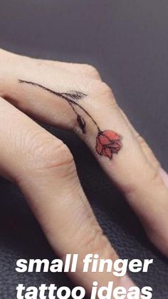 a woman's hand with a small flower tattoo on her left thumb and finger