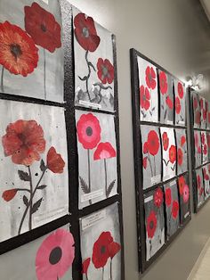 the hallway is decorated with red flowers and black framed pictures on the wall, along with white tile flooring