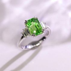 •Condition: Brand new•Center Stone: Natural Tsavorite, Baguette step cut, 2.07ct•Size: 9.2mm x 6.02mm x 4.00mm•Color: Vivid Green•Side stones: Natural White Diamond, Baguette-cut (VS1 clarity and F color)•Gold weight: 3.76g (depend on the ring size)•Metal Purity: Optional Each piece is made-to-order with care and special attention to detail. all items are made with conflict-free diamonds and gems.Size: made to orderThe item will be gift wrapped and shipped.--------------------------------------- Luxury Tsavorite Ring For May Birthstone, Luxury Green Moissanite Jewelry, Fine Jewelry Green Moissanite Emerald Ring, Fine Jewelry Emerald Moissanite Ring, Green Moissanite Emerald Ring In Fine Jewelry Style, Green Radiant Cut Diamond Ring With Gemstone, Green Moissanite Gemstone Jewelry, Green Moissanite Jewelry In Radiant Cut, Luxury Green Moissanite Emerald Ring