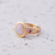 Our Sun Punch Ring has been set with a Crystal Opal from Coober Pedy and bead set with Pink Sapphires, G/VS White Diamonds and Salt & Pepper Diamonds in the band. Opal measures approx. 10 x 8mm. There are a total of three birlliant cut pink sapphires and four brilliant cut diamonds. Band width tapers from approx. 6mm to 3.4mm at the back of the band. Gold weight approx. 11g in 14ct. This ring is a size K in 14ct yellow gold with a matte finish. Please give us a call if you need this re-sized, we can take it up/down 1-2 sizes. If you would like this ring up/down beyond the 2 sizes, there is a $480 remake fee. Please note, we will match the opal as close to the image as possible. Each opal is unique and may vary in appearance and colour from what is depicted on the site. Coober Pedy, Crystal Opal, Bead Set, Stone Crystal, Salt And Pepper Diamond, Opal Crystal, White Opal, White Diamonds, Vintage Engagement Rings