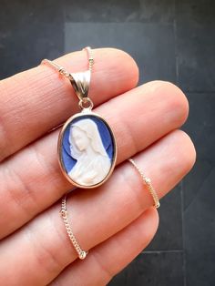 Blue Virgin Mary Cameo Necklace Cameos have stood the test of time as a timeless addition to any jewelry collection. Crafted with care, this handmade dolomite cameo from Italy is especially significant as it celebrates the purity of the Blessed Virgin Mary. This exquisite cameo necklace serves as a thoughtful gift for Christmas or any birthday, combining elegance with meaningful devotion. Elevate your jewelry collection with this unique piece that honors both beauty and history. This... Blue Medallion Jewelry For Anniversary, Blue Medallion Jewelry With Polished Finish, Oval Cameo Necklace For Keepsake, Elegant Round Miraculous Medal Jewelry, Elegant Oval Necklace With Miraculous Medal, Elegant Cameo Jewelry Keepsake, Oval Cameo Necklace Keepsake, Elegant Miraculous Medal Jewelry For Gift, Elegant Miraculous Medal Jewelry Gift