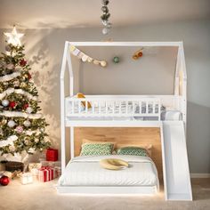 a white bunk bed sitting next to a christmas tree