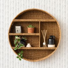 a wicker shelf with plants and candles on it