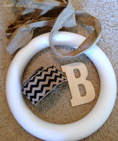 a wreath with the letter b on it and a ribbon hanging from it's end