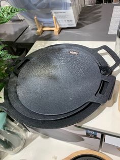 a black pan sitting on top of a counter next to a potted plant and other items